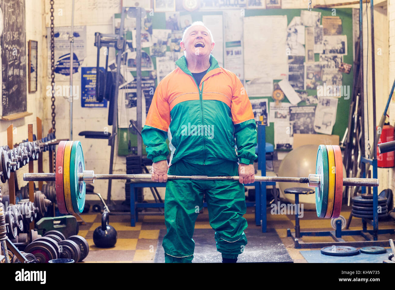 Senior male powerlifter struggling to lift barbell in gym Stock Photo