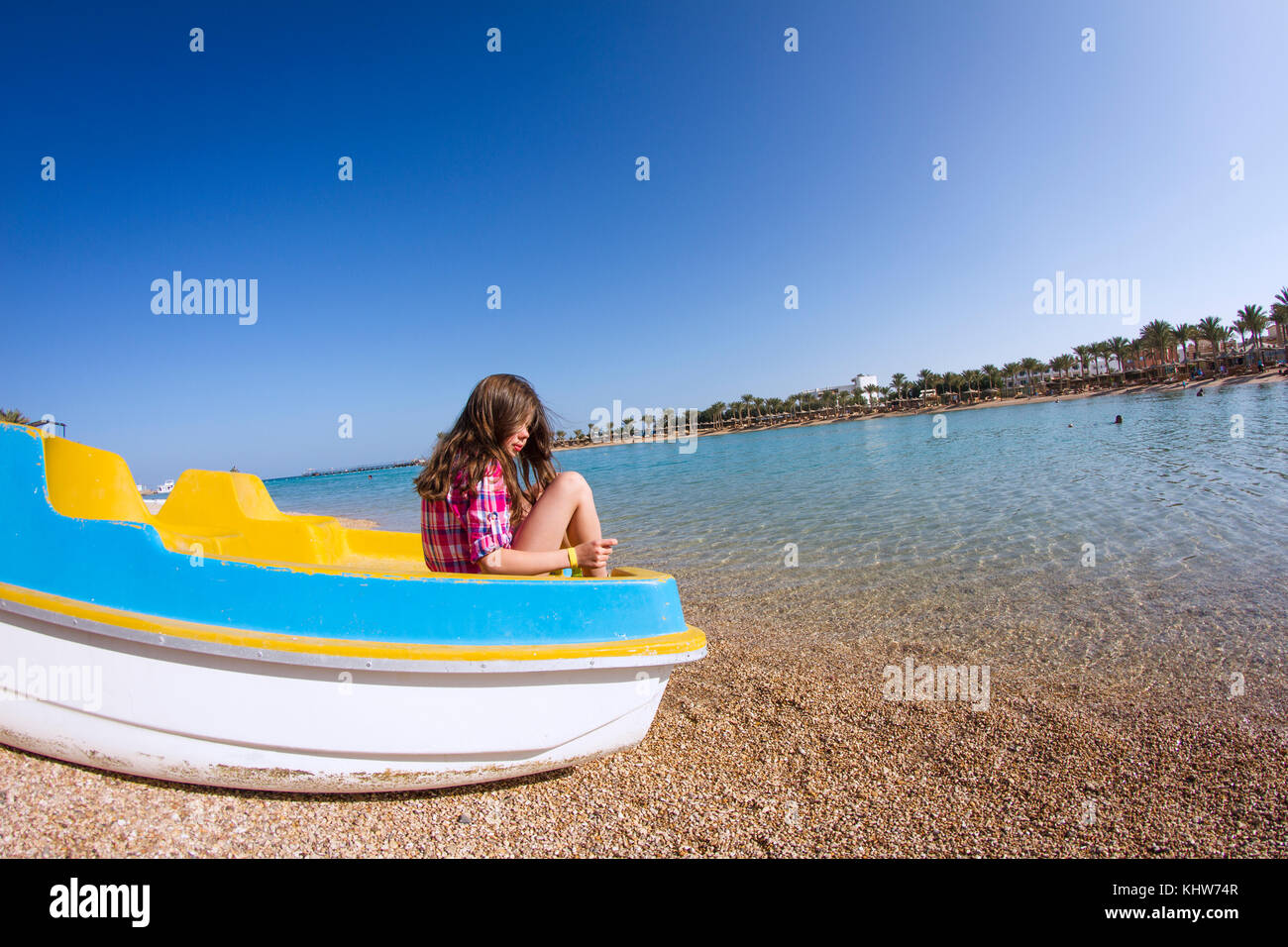 Girl sitting in a beached pedalo looking over her shoulder Stock Photo Alamy