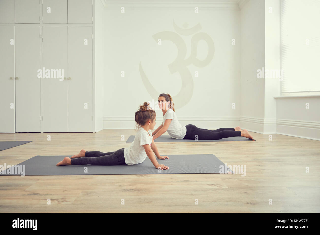 Mother and daughter in yoga studio, in yoga positions Stock Photo - Alamy