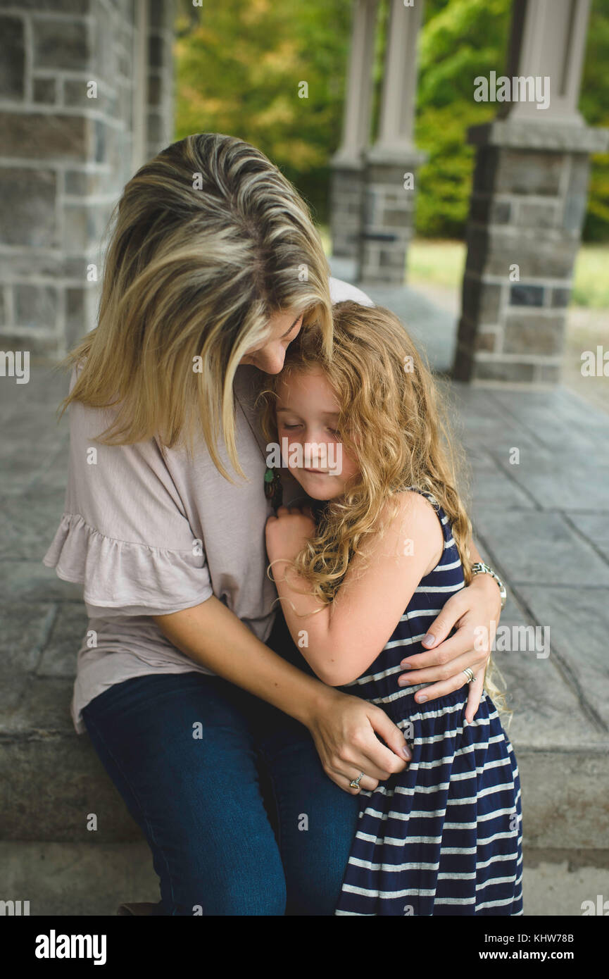 Mother consoling daughter on front porch Stock Photo
