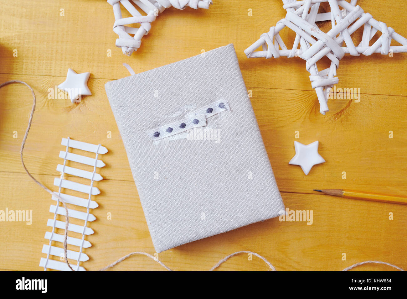 Notebook on a wooden background with a decor of white stars Flat lay, top view photo mockup Stock Photo