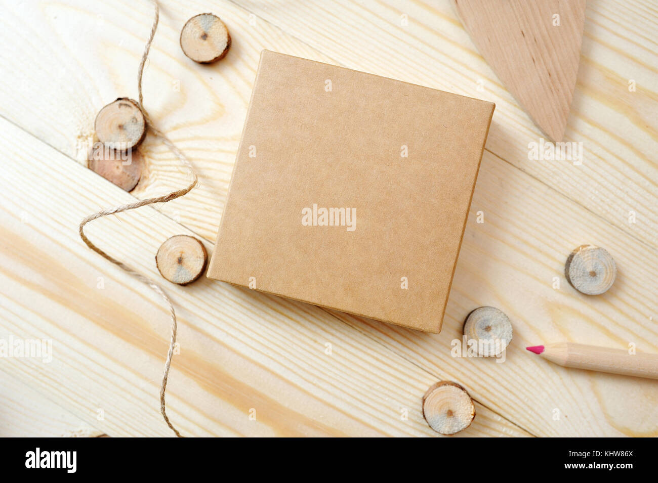 Kraft box with pencil on a wooden background. Flat lay, top view photo mock up Stock Photo