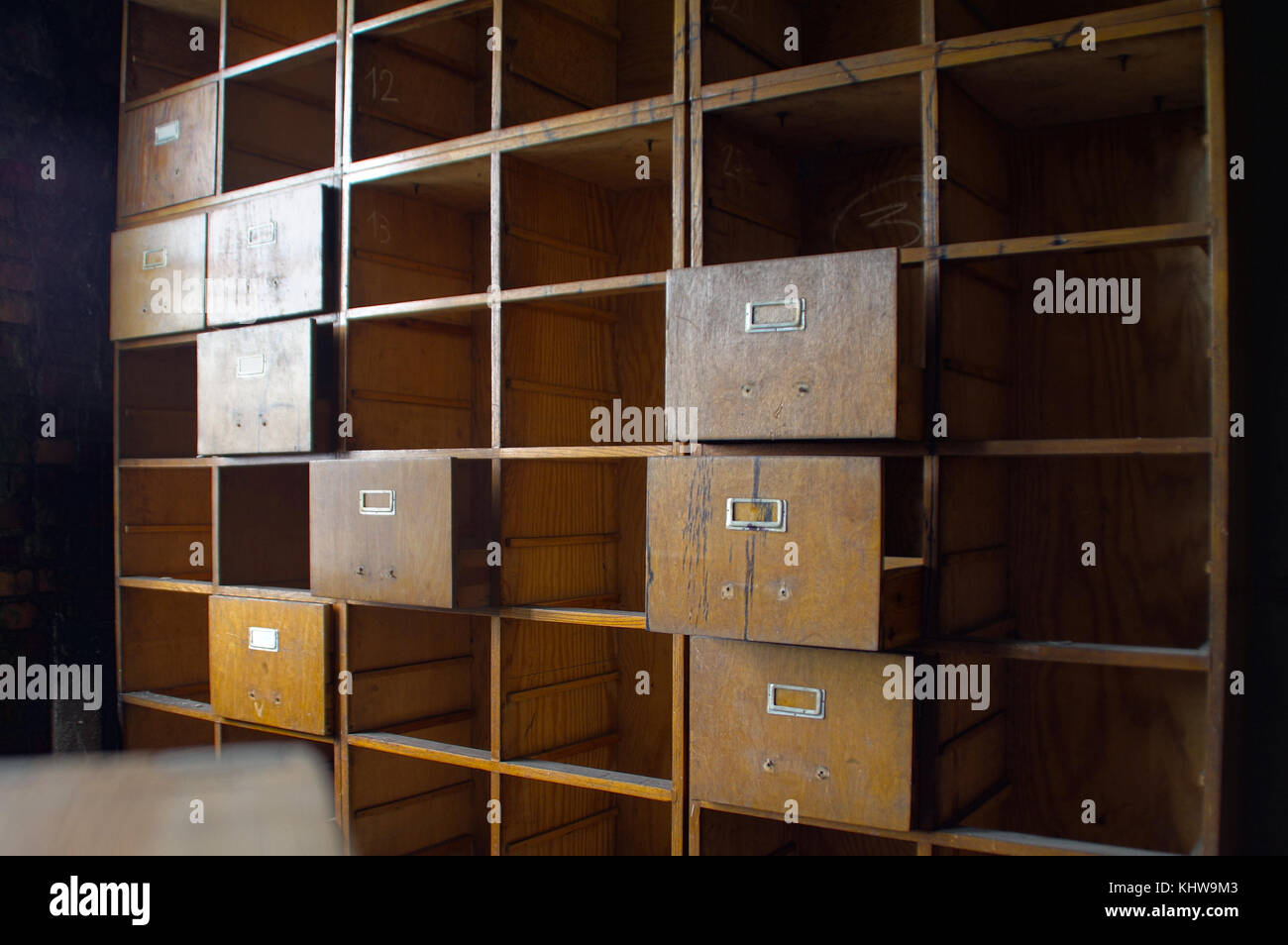 A forgotten empty document cabinet. Old damaged office wardrobe case with open drawers. Stock Photo