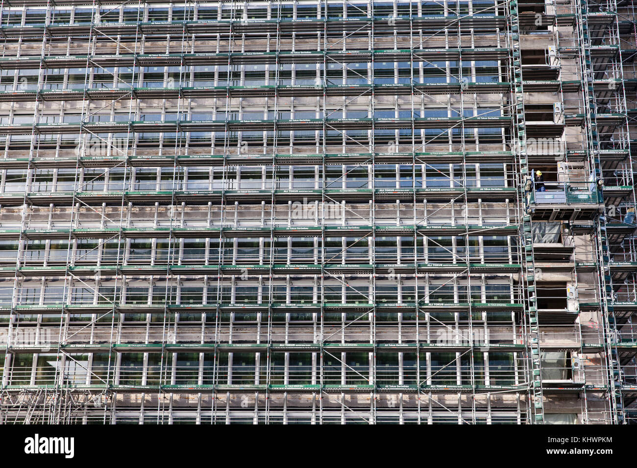 Germany, Cologne, a scaffolded office building at the Venloer street, a lonely worker.  Deutschland, Koeln, Baugeruest an einem Buerohochhaus an der V Stock Photo