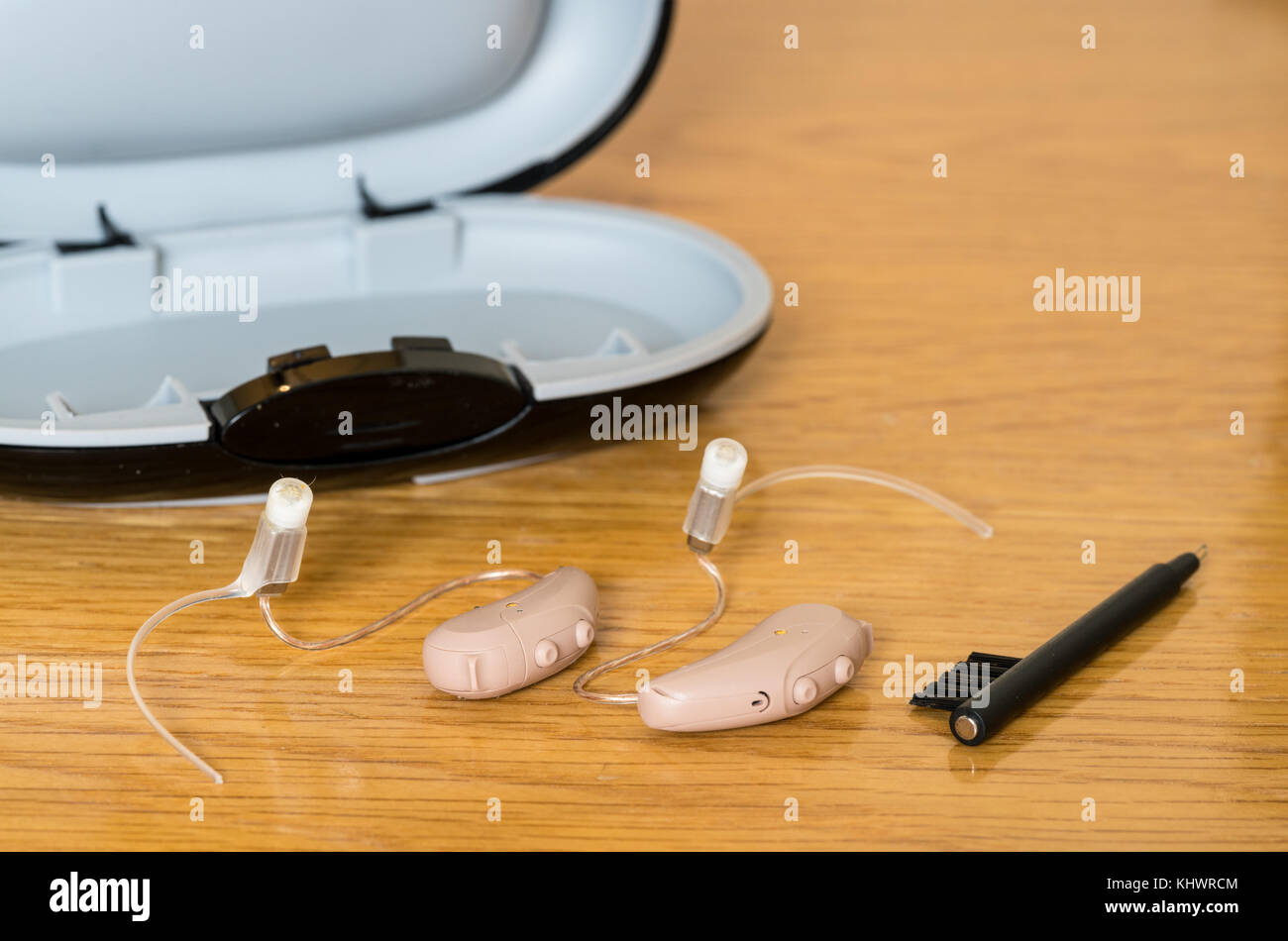 Close up of a pair of tiny modern hearing aid on bedside table Stock Photo