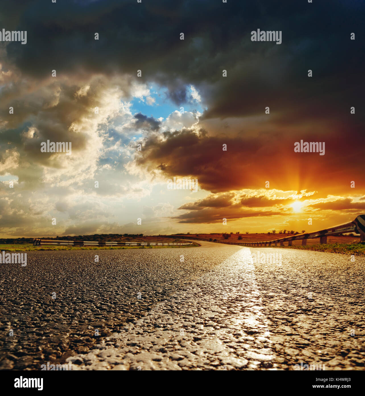 low orange sunset in dramatic clouds over asphalt road Stock Photo - Alamy