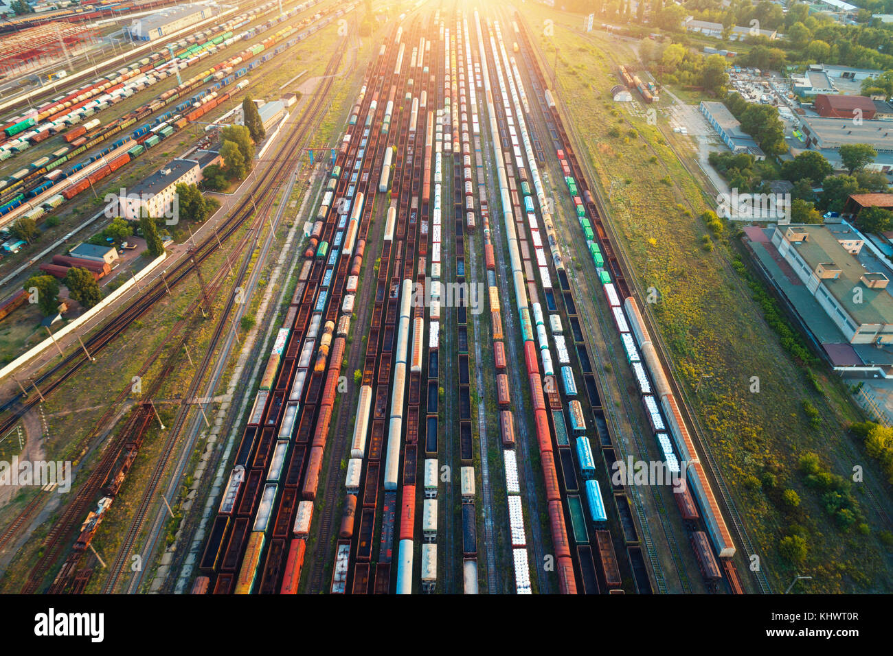 Top view of colorful cargo trains. Aerial view from flying drone of colorful freight trains on the railway station. Wagons with goods on railroad. Hea Stock Photo