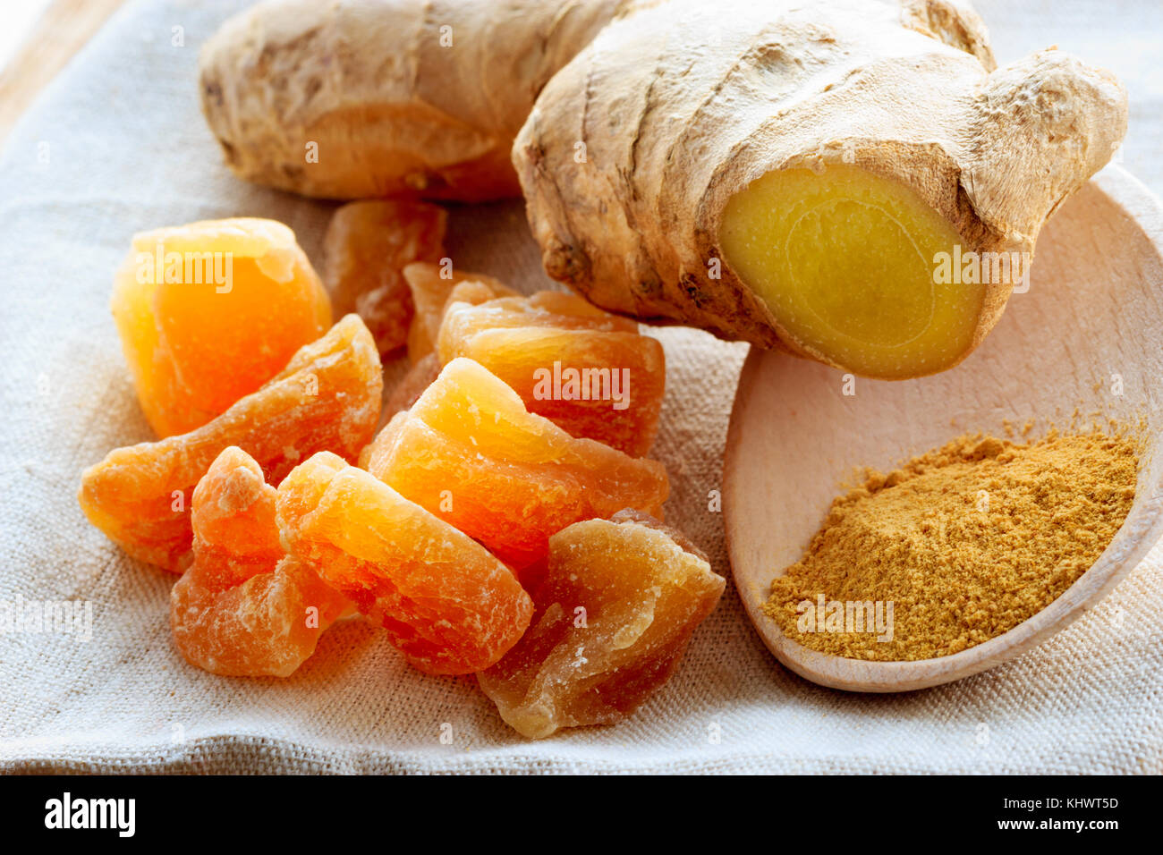 Three kinds of ginger ground spice fresh and candied on rustic table