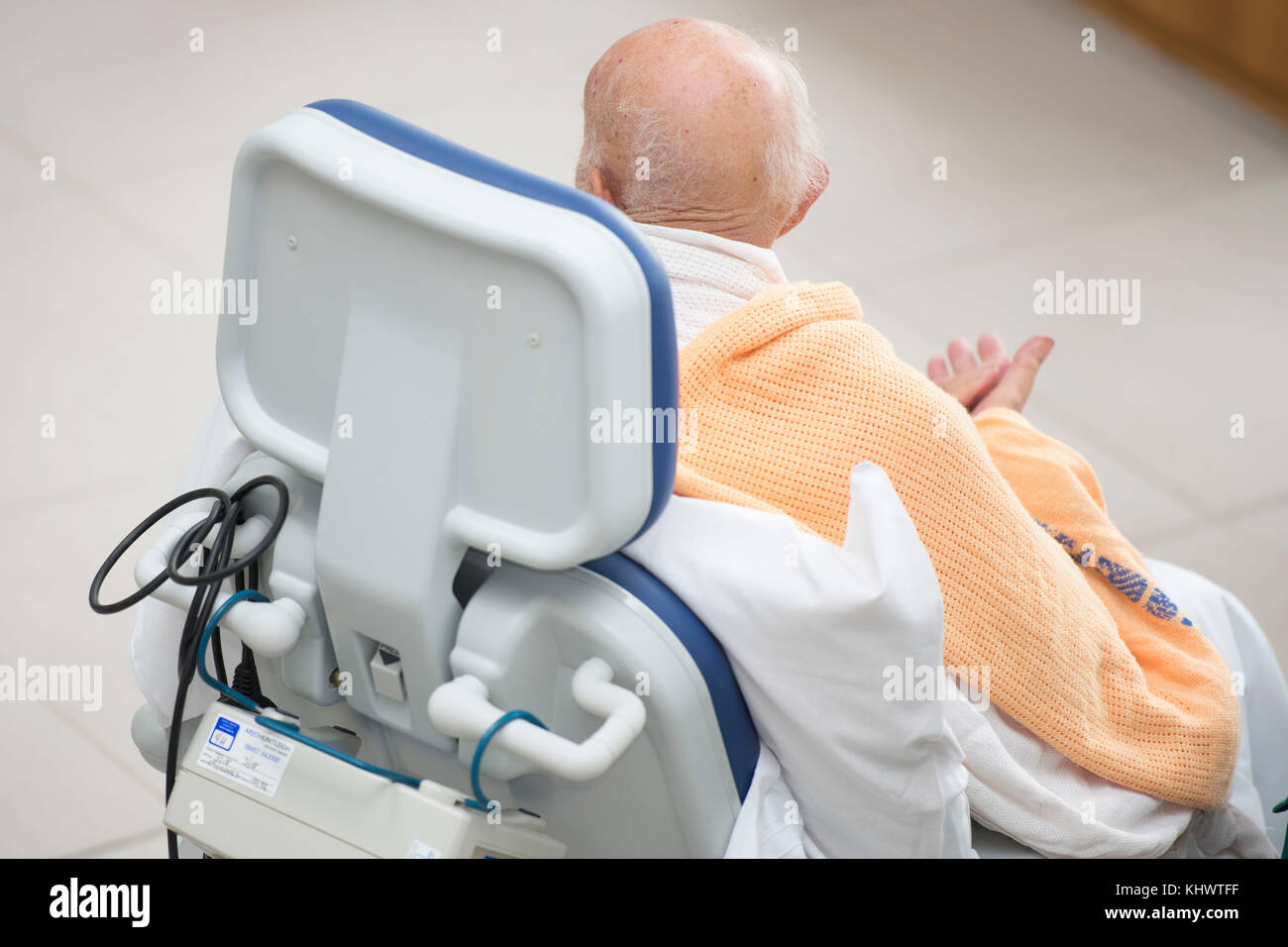 An elderly NHS patient in a hospital bed chair Stock Photo