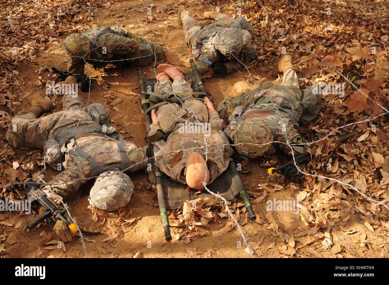 During 8th Army’s 2017 Expert Field Medical Badge familiarization week at Warrior Base, Republic of Korea, four EFMB candidates practice navigating a simulated casualty under an obstacle during a testing lane, November 11, 2017. EFMB candidates were given two weeks of familiarization before four days of intense testing that whittled the field of 139 candidates down to 20. (U.S. Army photo by Staff Sgt. Ben Hutto, RELEASED) Stock Photo