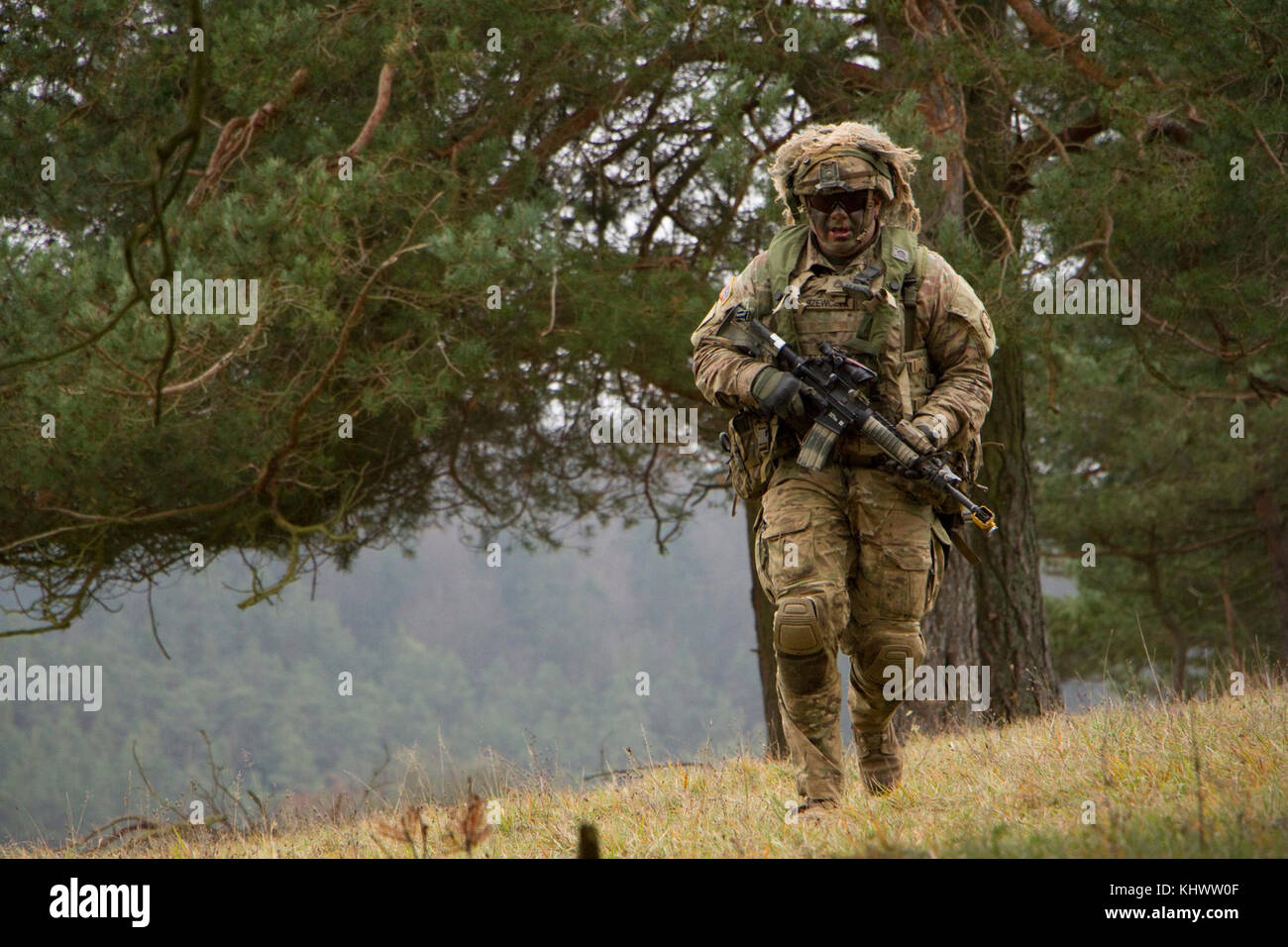 Staff Sgt. Marcin Szewczyk from 1st Squadron, 2d Cavalry Regiment runs for cover while taking part in a battle against opposing forces during Allied Spirit VII at the 7th Army Training Command's Hohenfels Training Area, Germany, Oct. 30 to Nov. 22, 2017. Allied Spirit is a U.S. Army Europe-directed, 7ATC-conducted multinational exercise series designated to develop and enhance NATO nations interoperability and readiness. Stock Photo