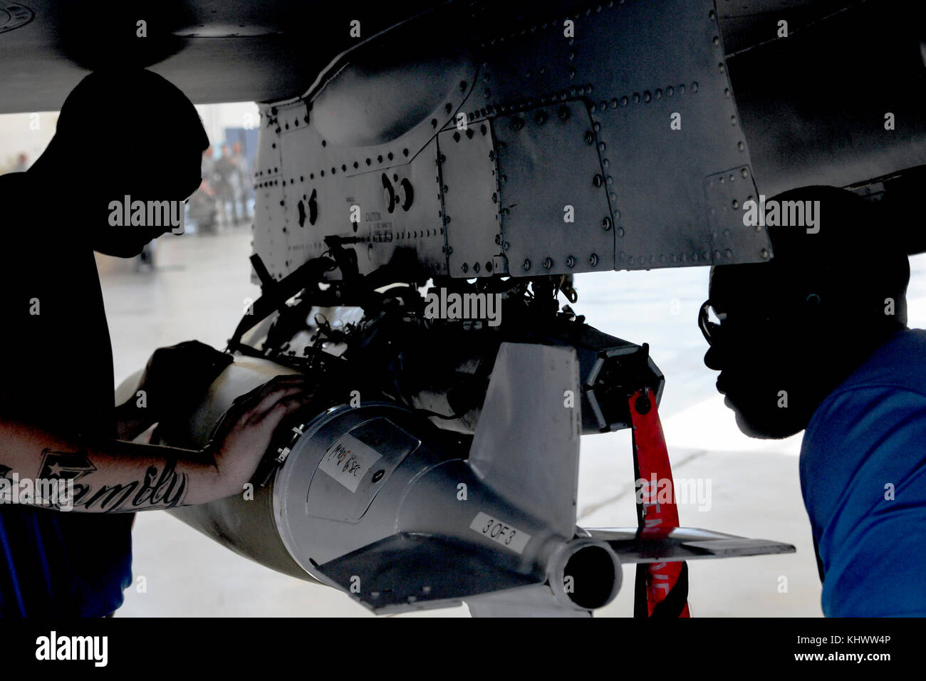 Staff Sgt. Jonathon Greg, 74th Aircraft Maintenance Unit (AMU) crew chief and Senior Airman Rodney Brown, 74th AMU load crew member, loads a MK84 bomb on an A-10C Thunderbolt II, during a quarterly weapons load competition, Nov. 16, 2017, at Moody Air Force Base, Ga. Judges evaluated the competitors based on dress and appearance, a knowledge exam and loading various munitions to determine the swiftest and most efficient load crew. (U.S. Air Force photo by Airman Eugene Oliver) Stock Photo