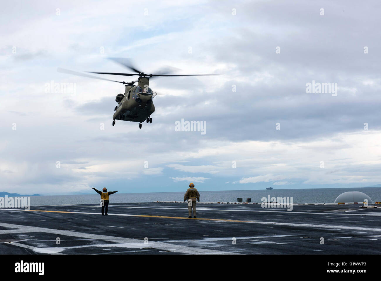 171116-N-UH661-050 STRAIT OF JUAN DE FUCA (Nov. 16, 2017) A Sailor directs a CH-47 Chinook assigned to the Washington Air National Guard for takeoff on USS John C. Stennis' (CVN 74) flight deck. John C. Stennis is returning to homeport after the successful completion of a two-week underway where the ship’s crew conducted training to prepare for its next scheduled deployment.  (U.S. Navy photo by Mass Communication Specialist 3rd Class Mike Pernick/Released) Stock Photo