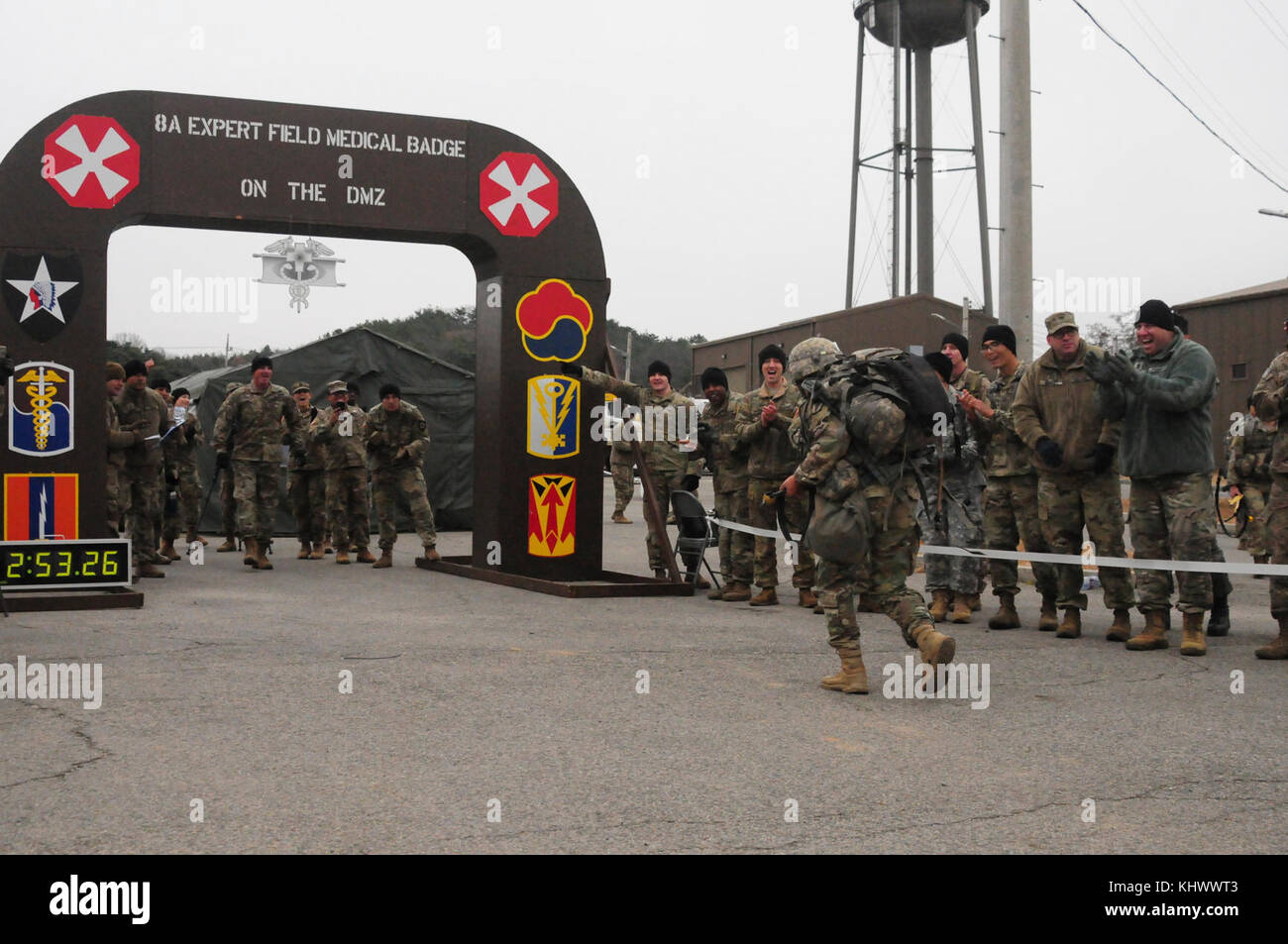 As onlookers cheer, one of the final 20 candidates for 8th Army’s 2017 Expert Field Medical Badge rushed towards the finish line of  final the twelve-mile foot march of 8th Army’s 2017 Expert Field Medic’s at Warrior Base, Republic of Korea, November 11, 2017. One hundred-thirty nine candidates traveled to Warrior Base from across the Korean Peninsula to compete for the badge. (U.S. Army photo by Staff Sgt. Ben Hutto, RELEASED) Stock Photo