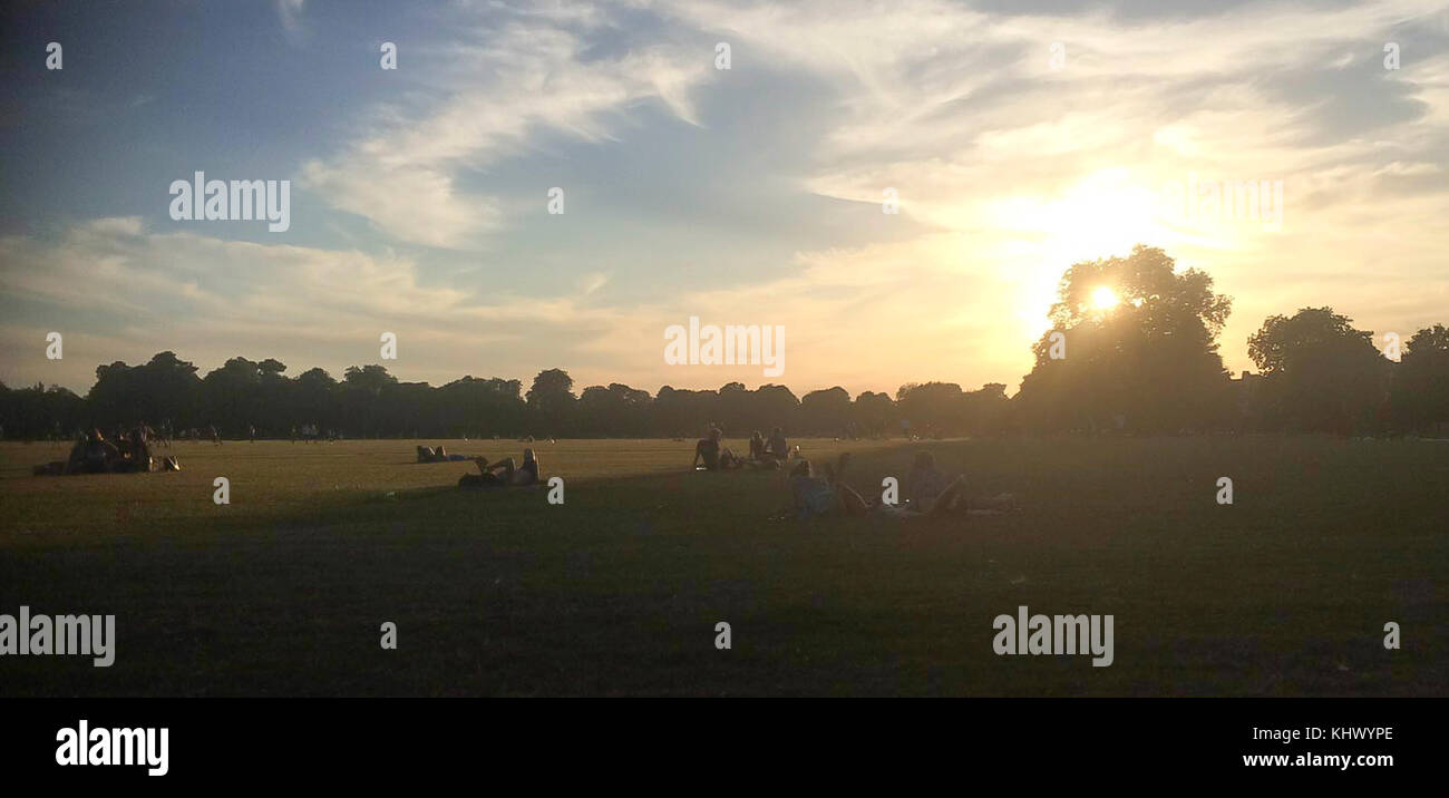 People relaxing in a park on a beautiful summers evening Stock Photo