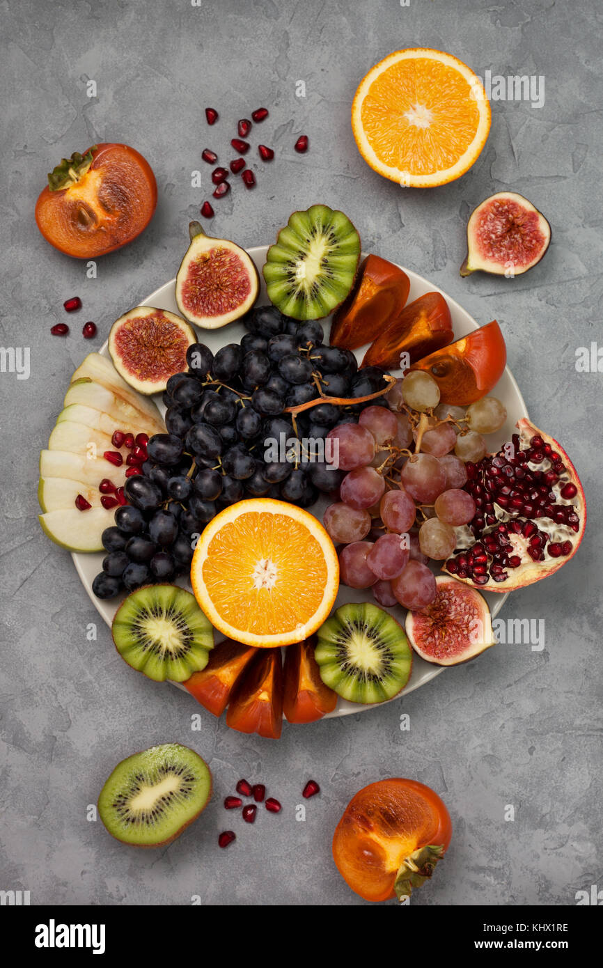 platter of fresh fruits oranges, grapes, kiwi, persimmons, figs