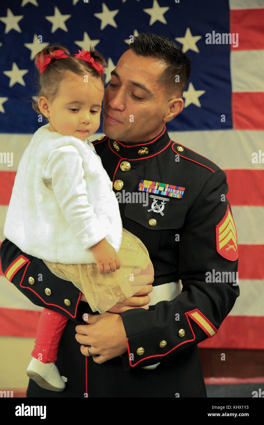 MONTROSE, CO – Marine Corps veteran Sgt. Eubaldo Lovato, a Silver Star recipient, holds his daughter prior to his Silver Star award ceremony in Montrose, Colo., Nov. 18, 2017. Lovato received an award upgrade, from his previous Bronze Star, for his heroic actions while serving as a squad leader with Company A, 1st Battalion, 8th Marine Regiment, 1st Marine Division, during Operation Al Fajr, part of Operation Iraqi Freedom, on Nov. 15, 2004. The Silver Star is the United States third-highest personal decoration for valor in combat. (U.S. Marine Corps photo by Pfc. Samantha Schwoch/Released) Stock Photo