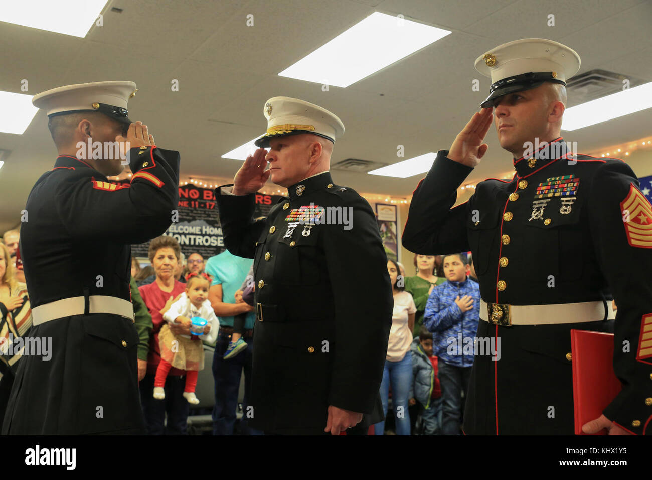 Marine Corps veteran Sgt. Eubaldo Lovato (left), Silver Star recipient, Brig. Gen. Michael Martin (center), deputy commanding general of Marine Corps Forces Command, and Sgt. Maj. Bryan Fuller, Inspector Instructor Sgt. Maj. of Combat Logistics Group 453 Sgt. Maj., 4th Marine Logistics Group, render honors during the playing of the National Anthem during the Silver Star award ceremony in Montrose, Colo., Nov. 18, 2017. Lovato received an award upgrade, from his previous Bronze Star, for his heroic actions while serving as a squad leader with Company A, 1st Battalion, 8th Marine Regiment, 1st M Stock Photo
