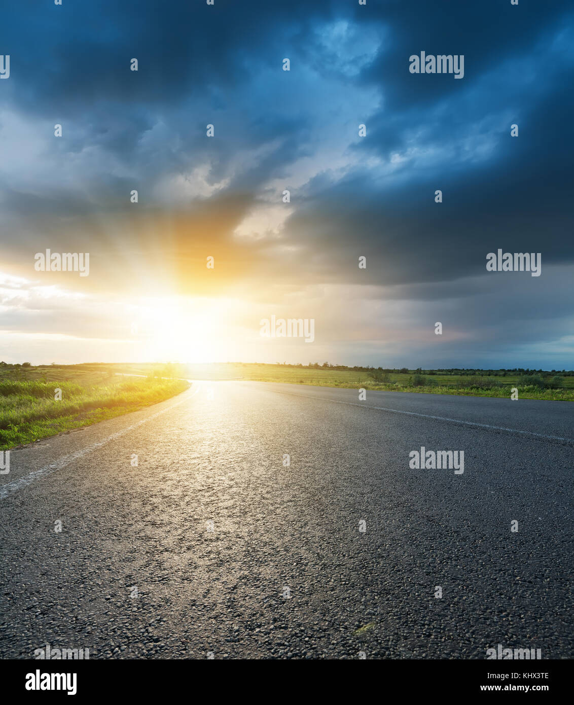sunset in dark low clouds over asphalt road Stock Photo - Alamy