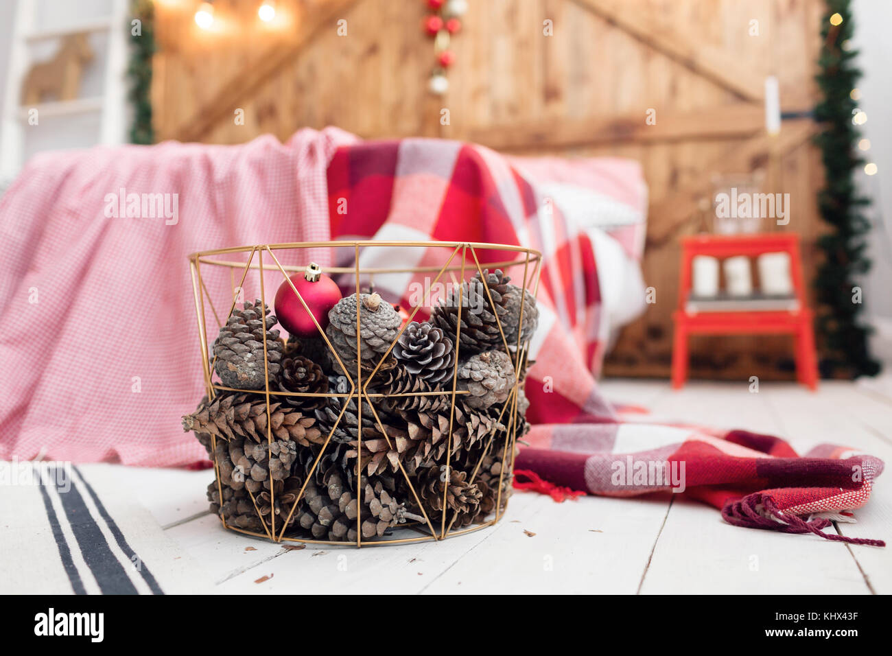 Christmas decorations in basket and pine cones on floor close up Stock ...