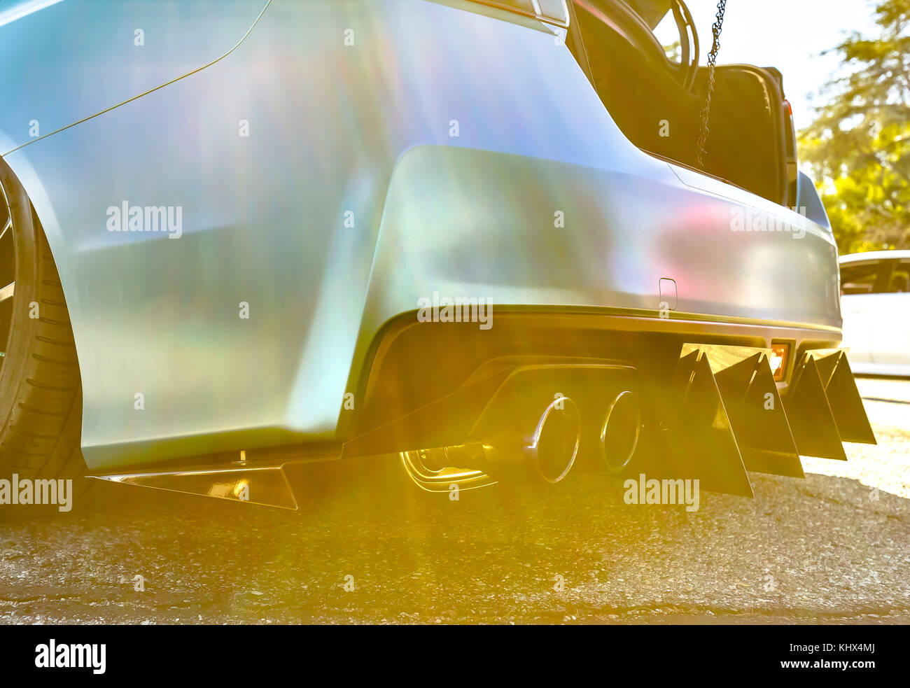 Dual exhaust on a custom car with light leaks and lens flare. Custom