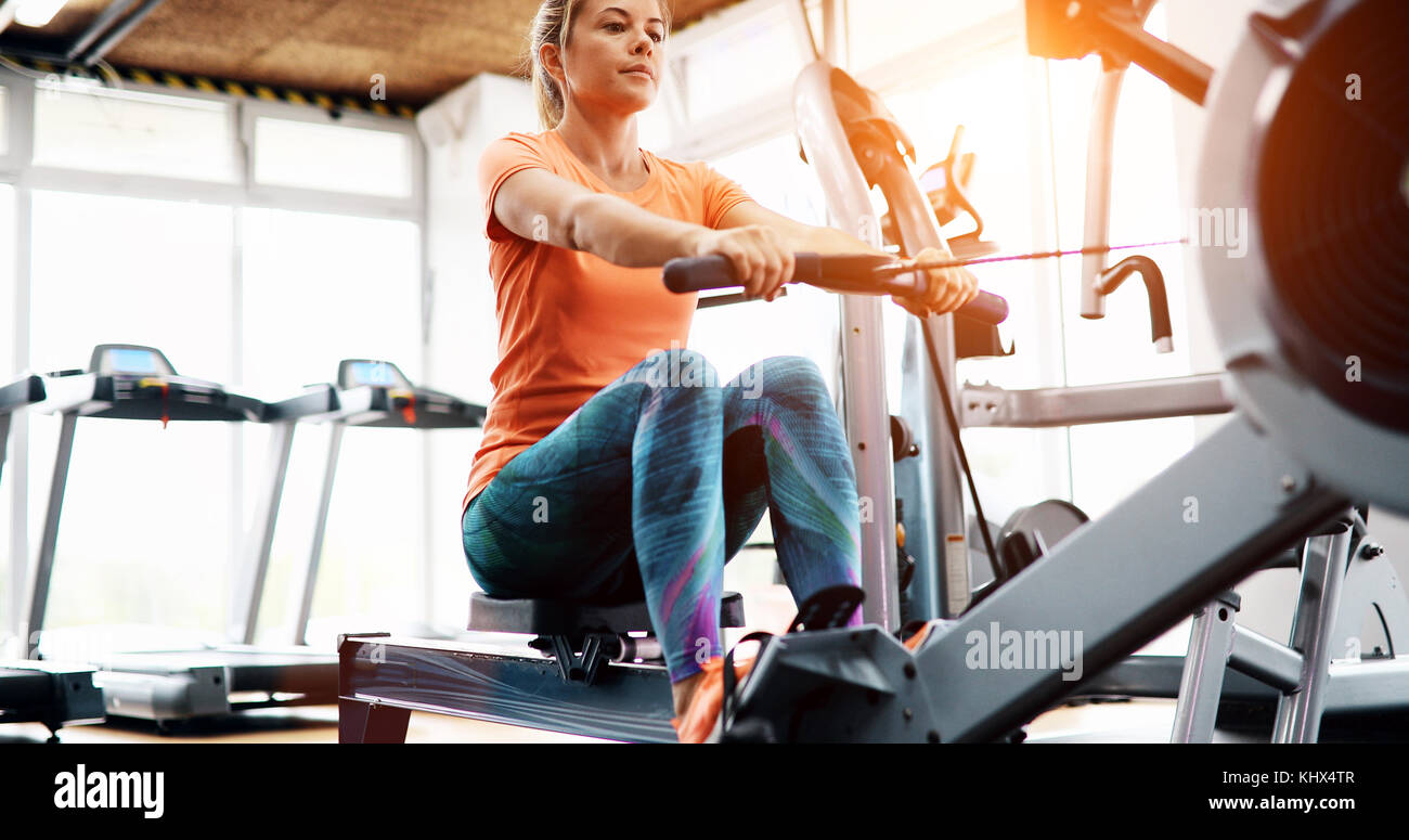 Young blonde woman working on rowing machine Stock Photo