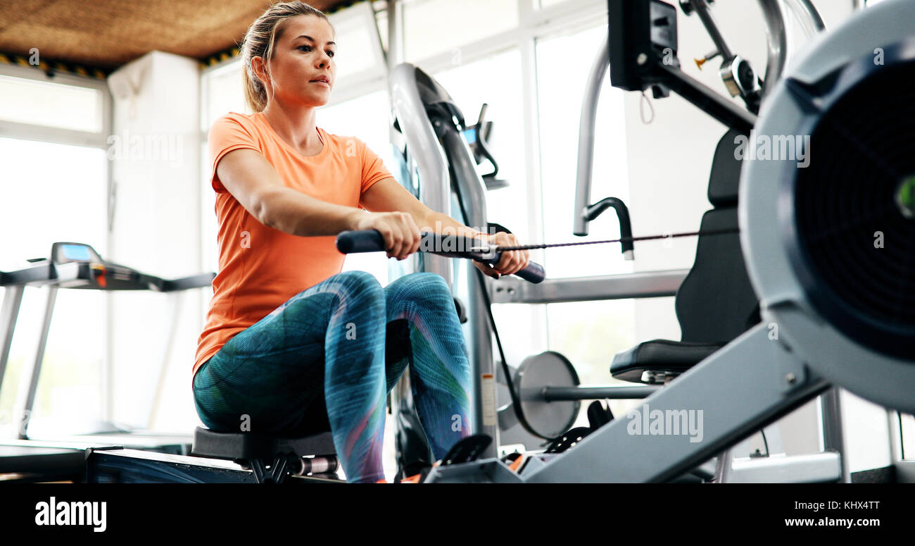 Young blonde woman working on rowing machine Stock Photo