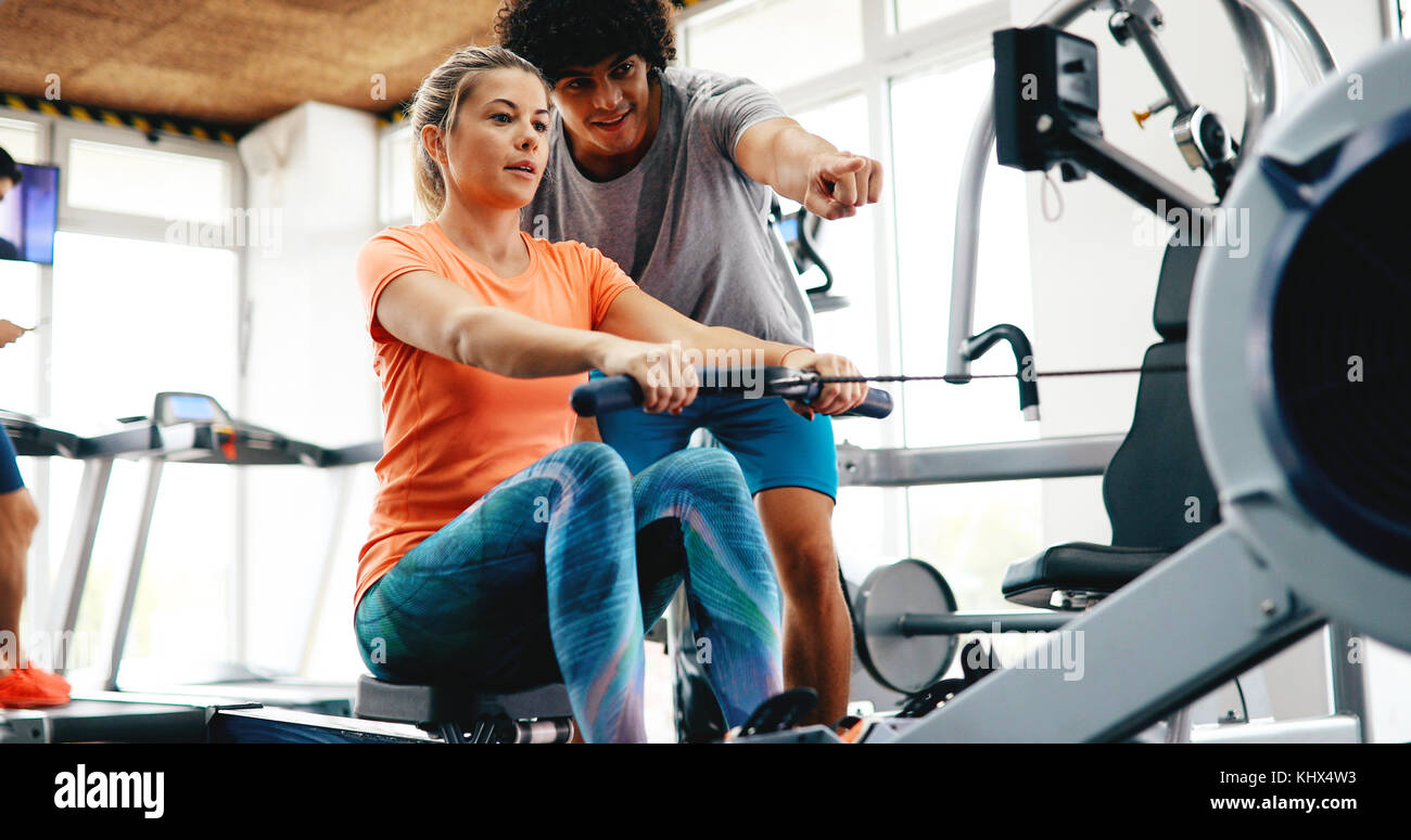 Young beautiful woman doing exercises with personal trainer Stock Photo