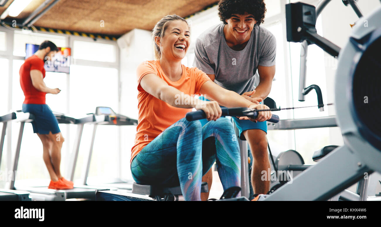 Young beautiful woman doing exercises with personal trainer Stock Photo