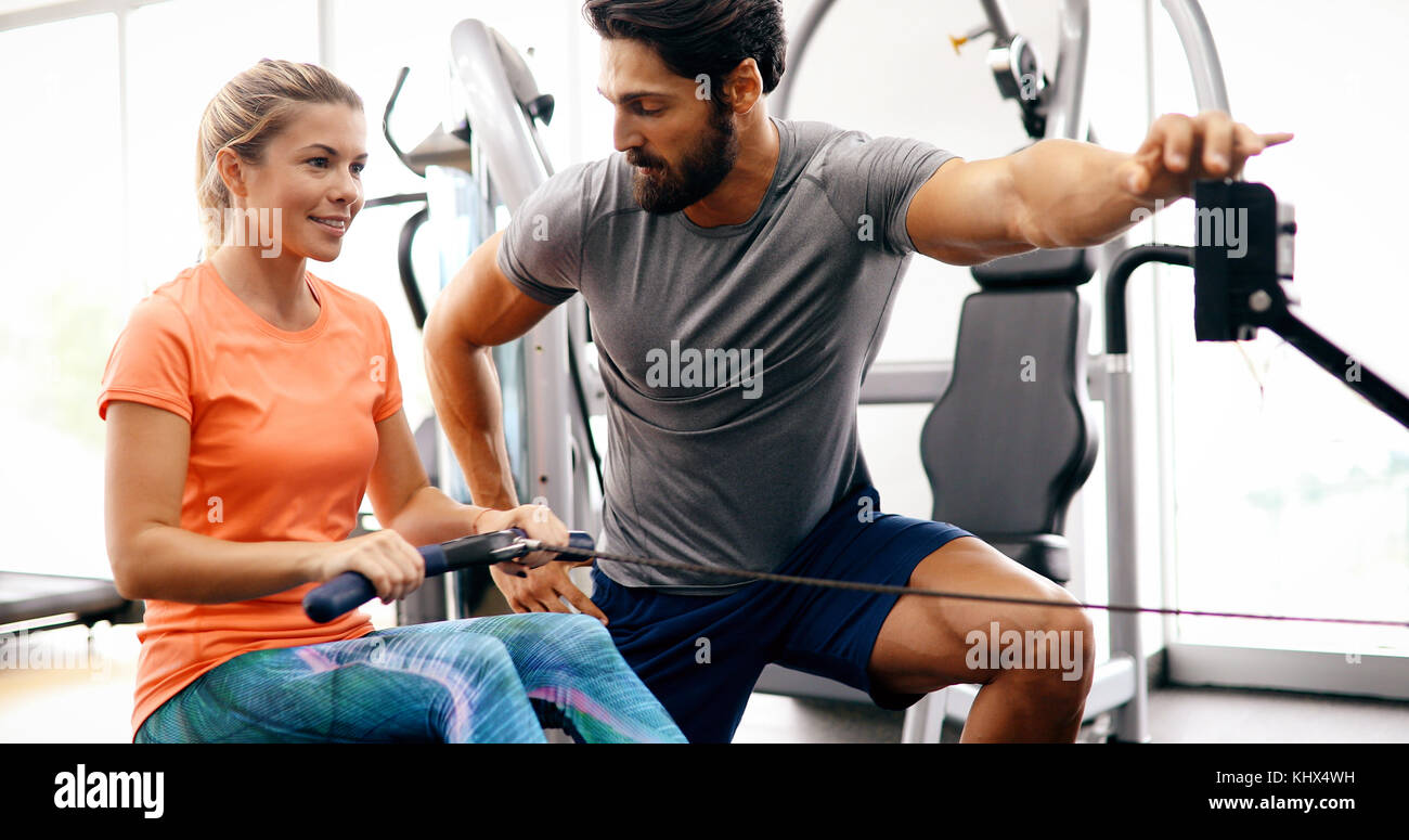 Young beautiful woman doing exercises with personal trainer Stock Photo