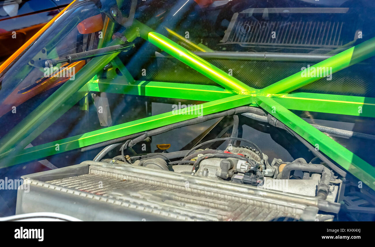 Green metal bars of a roll cage in the back of a car. Custom cars in