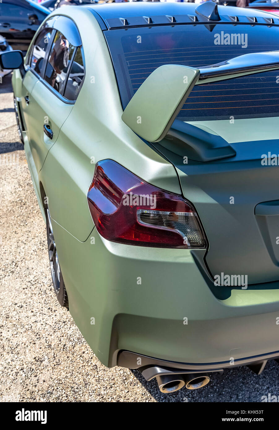 Matte green car with dark tail lights and spoiler. Custom cars in Southern California summer
