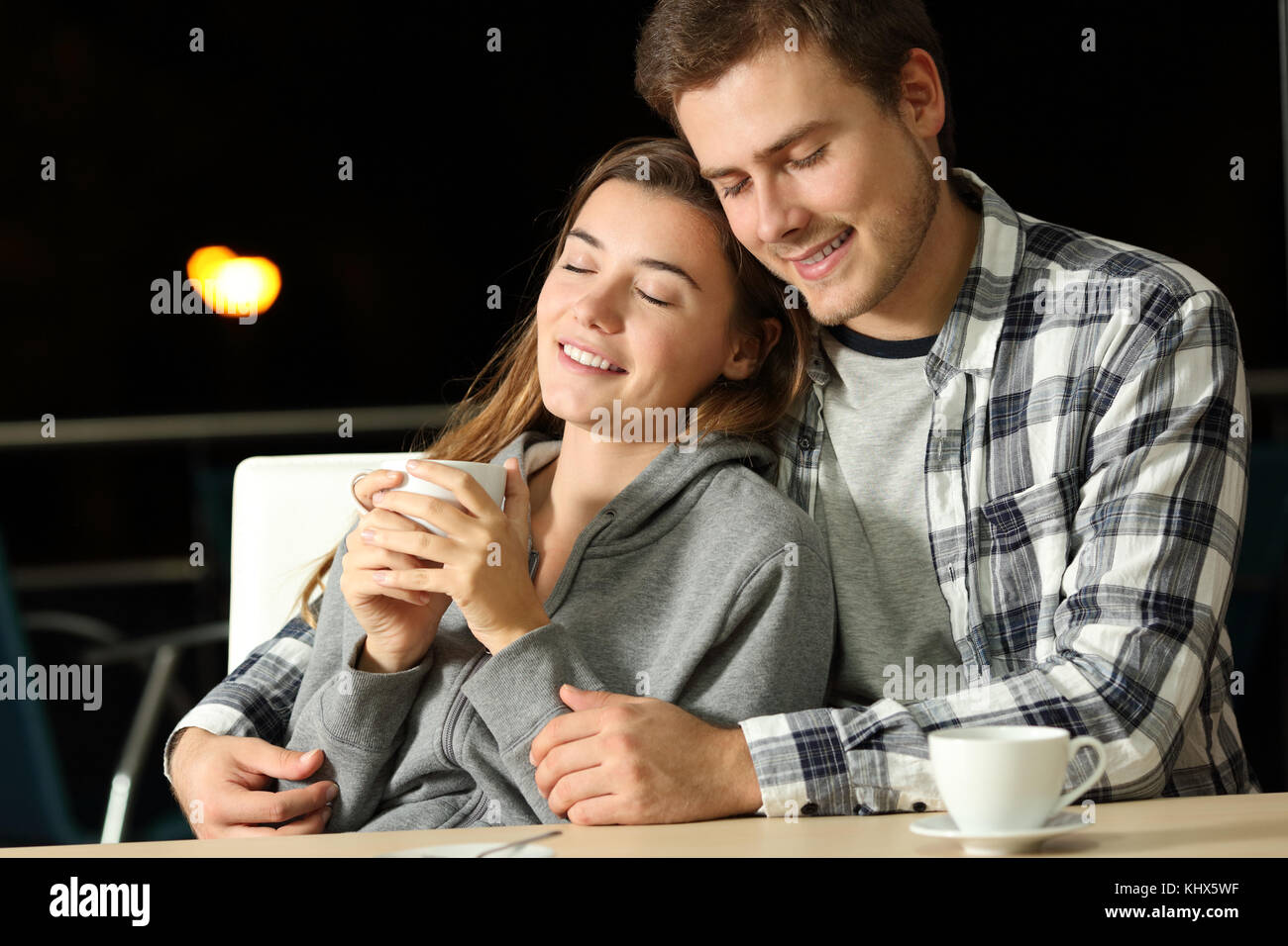 Enamored couple of teenagers dating in a bar in the night Stock Photo