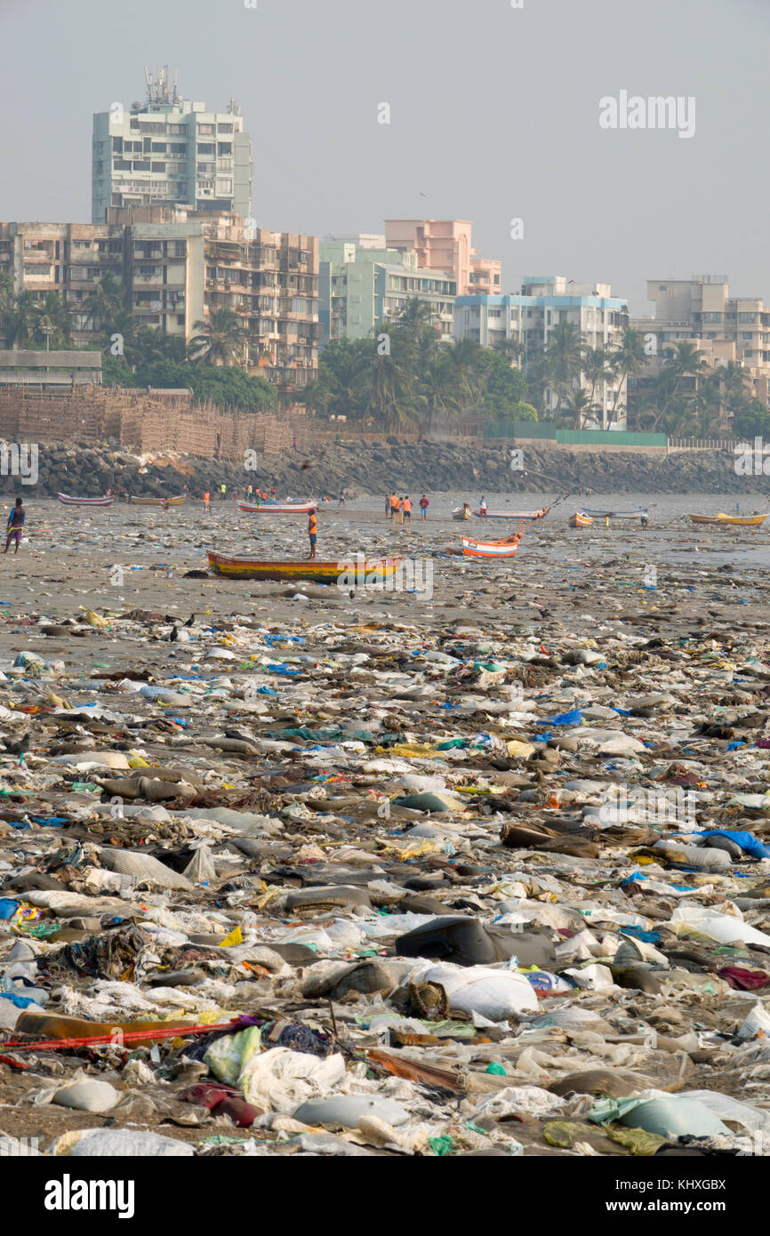 Small fishing boats surrounded by plastic garbage and other rubbish on Versova Beach, Mumbai Stock Photo