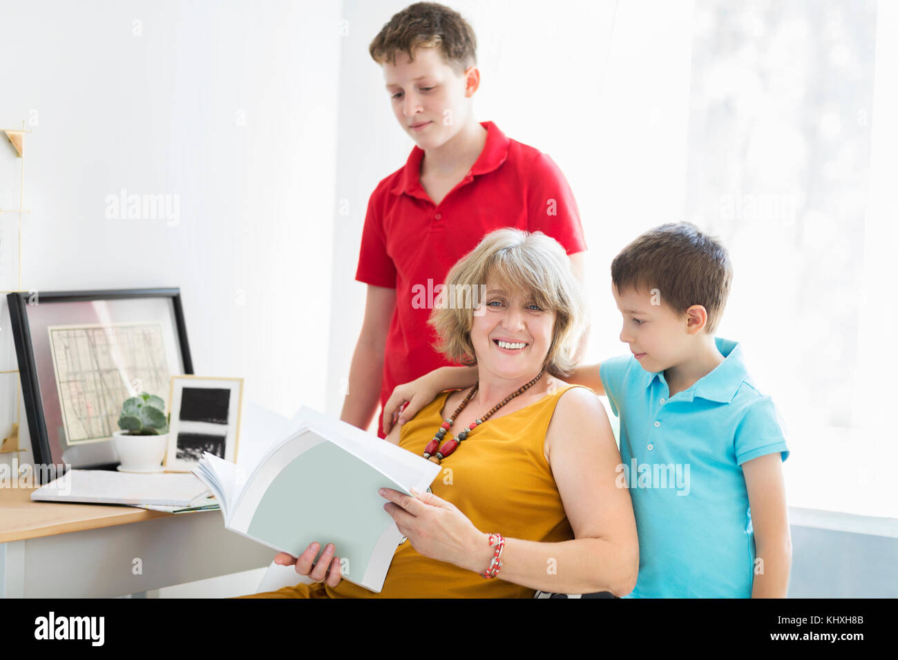 Mid-age woman with two young boys indoors. Family concept Stock Photo