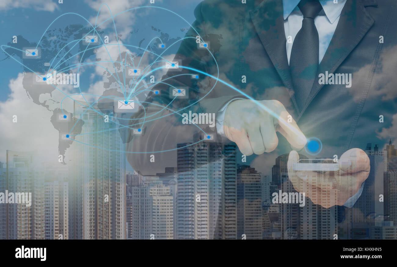 Double exposure of businessman using the smart phone with sending the email via network line on cityscape background, business concept Stock Photo