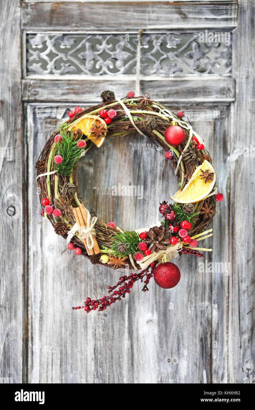 Christmas handmade wreath on wooden door. Winter holiday celebration concept Stock Photo