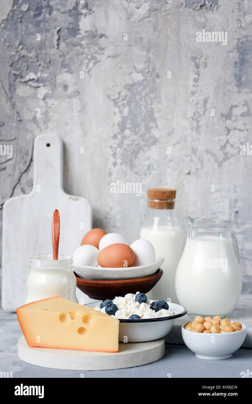 Dairy products on marble table over concrete background. Cheese, farmers cheese, milk, yogurt, sour cream, eggs and smoked cheese. Organic farmers dai Stock Photo