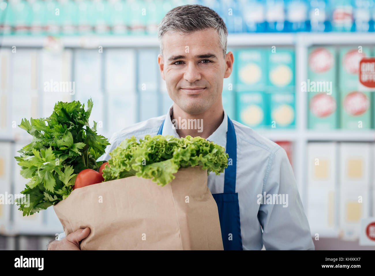 Professional supermarket clerk holding a grocery bag with fresh