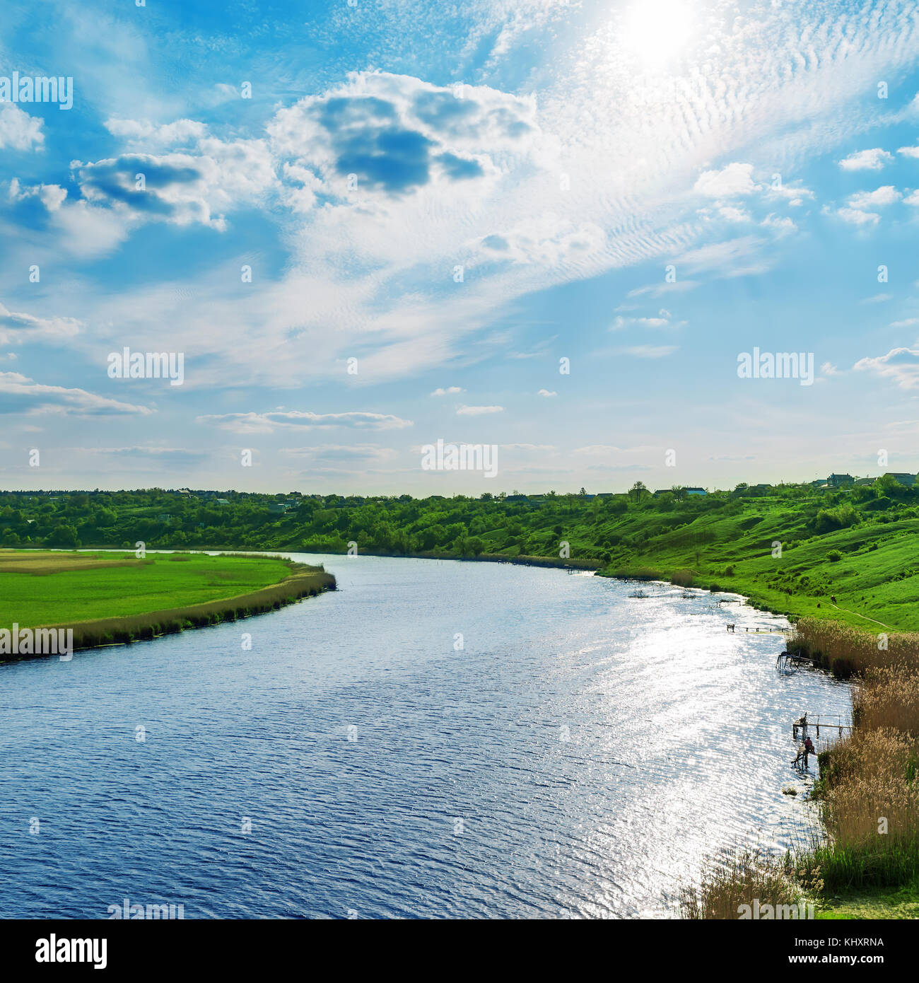 sun with clouds in blue sky over river Stock Photo - Alamy