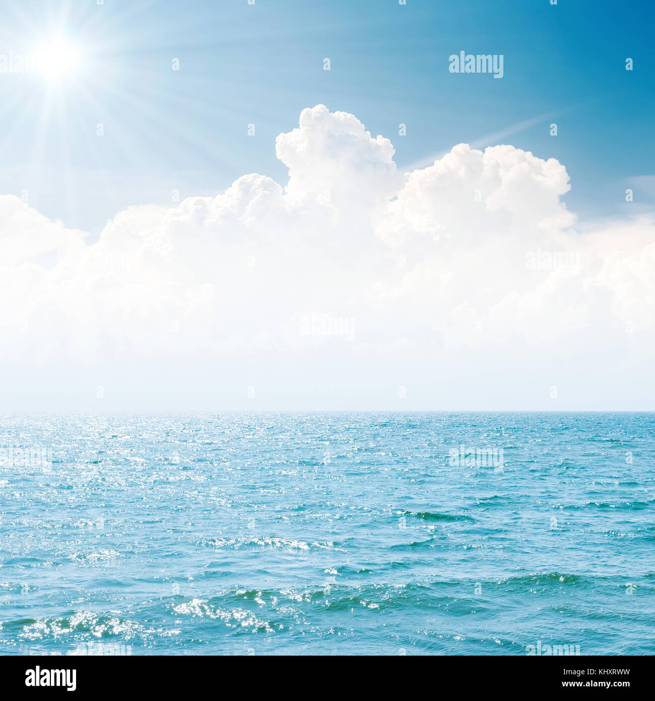 sun in blue sky over white clouds and sea Stock Photo - Alamy
