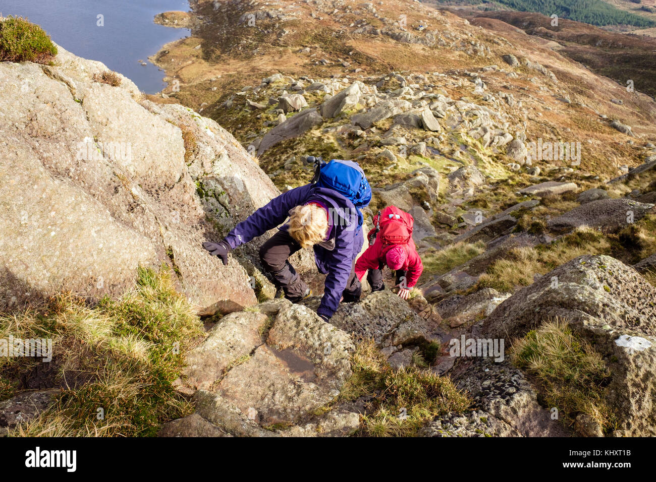 Two hikers climbing on Daear Ddu east ridge rock scramble route on Carnedd Moel Siabod mountain in mountains of Snowdonia National Park. Wales UK Stock Photo