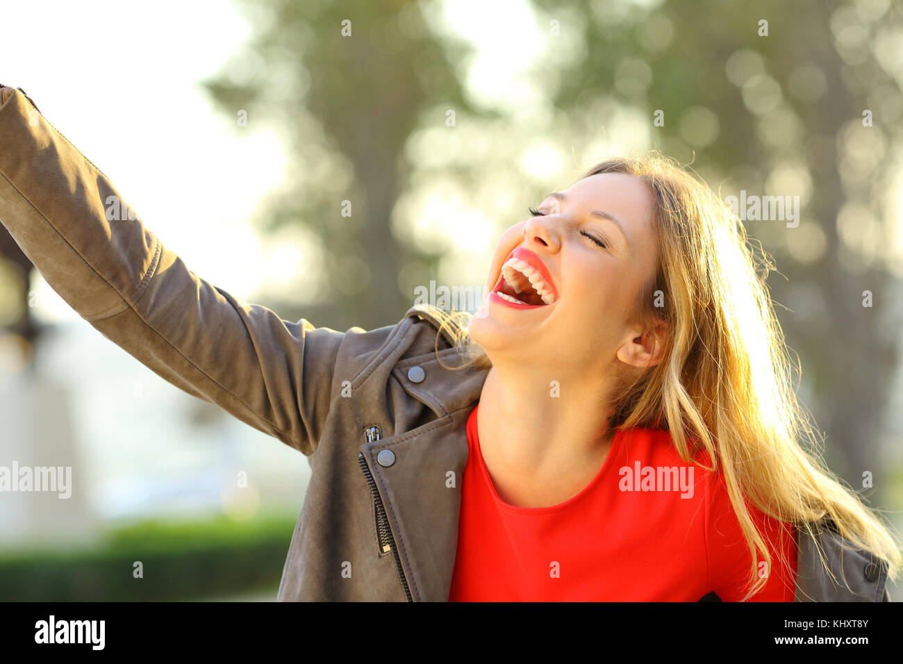 Funny fashion woman laughing and joking outdoors in a park Stock Photo