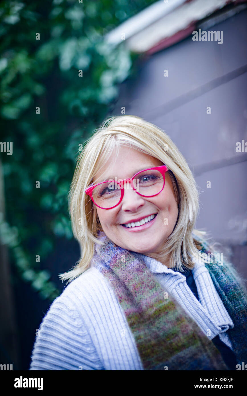 Portrait of mature woman wearing red spectacles outside house Stock Photo