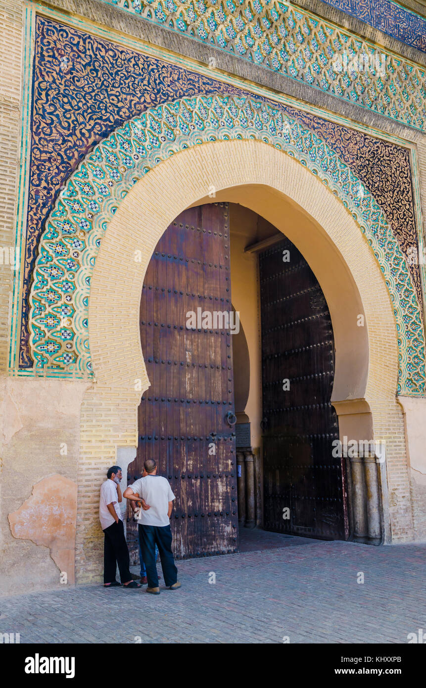 Meknes, Morocco - August 21 2013: Three unidentified Moroccan men talking in front of historic Bab Mansour Gate Stock Photo
