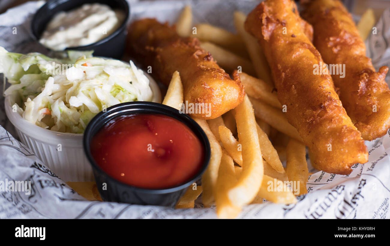 Tasty fish and chips, coleslaw and salsas served in English style on a