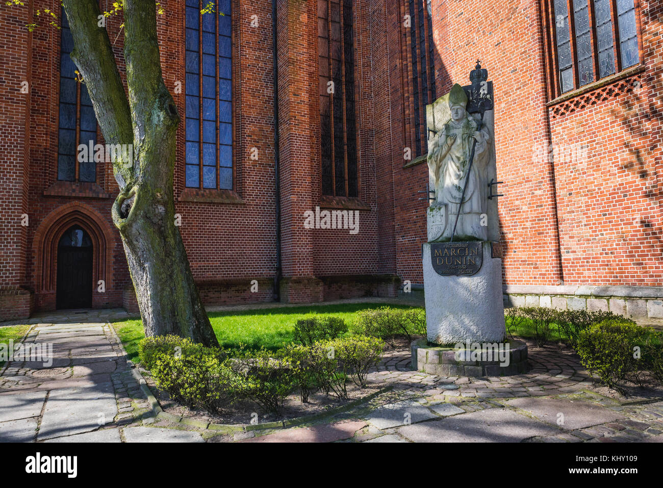 Archbishop Marcin Dunin statue in front of gothic style Co-Cathedral Basilica of the Assumption of the Blessed Virgin Mary in Kolobrzeg city, Poland Stock Photo