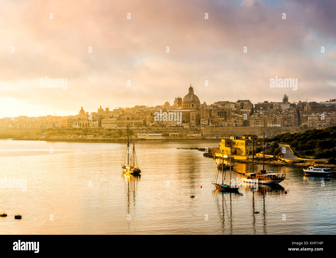 warm sunrise outlines the maltese capital of valletta Stock Photo