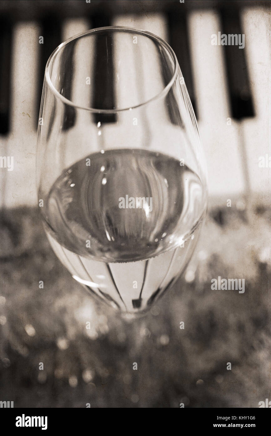 Artwork in vintage style, reflection of piano keys in wine glass