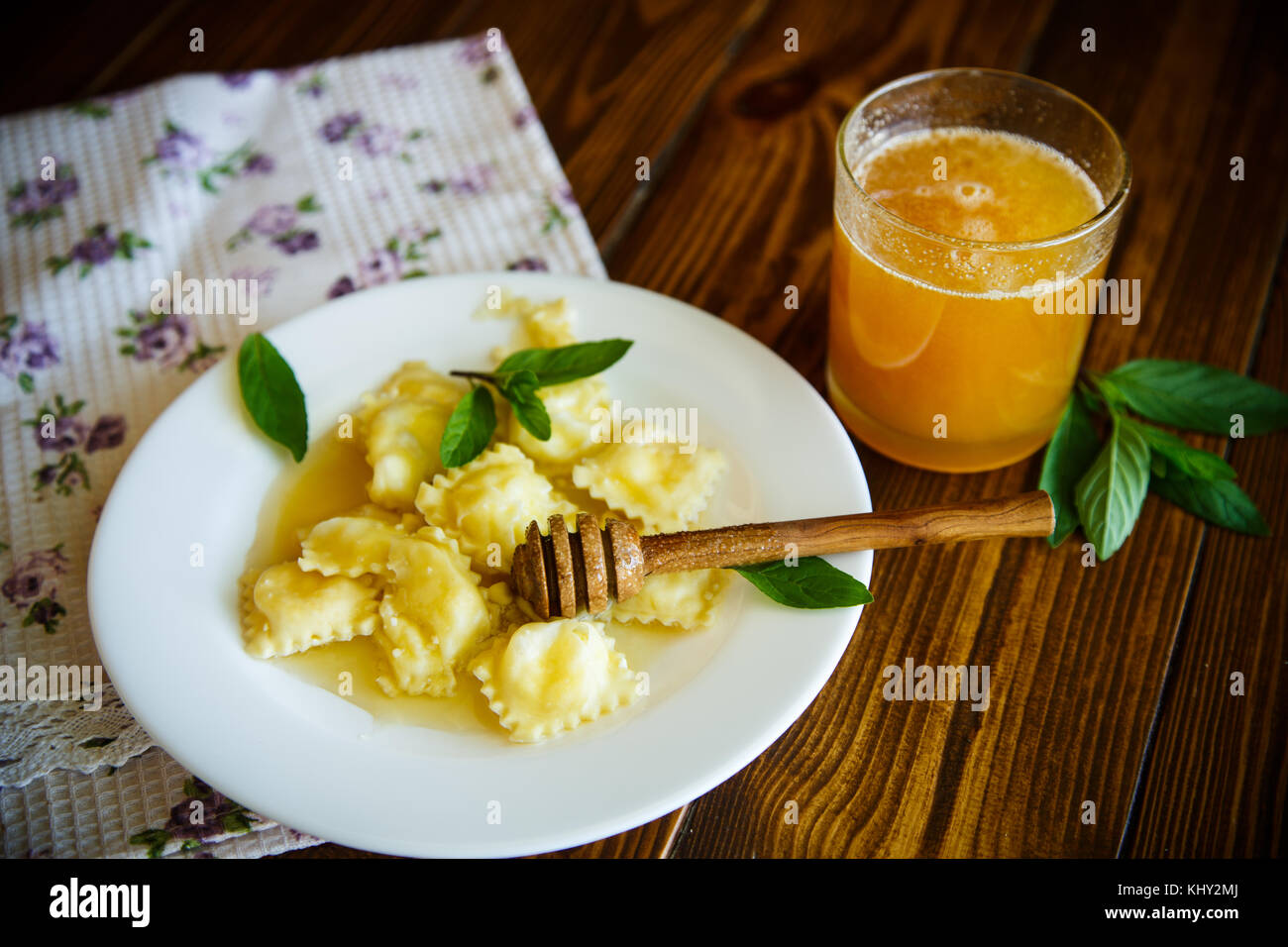 Homemade sweet ravioli with cottage cheese and honey on a wooden table ...